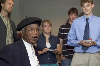 Chinua Achebe talks with the winners of an essay contest