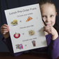 Child holding pre-order for school lunch.