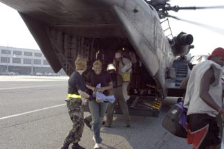 hurricane survivor smiles as she exits a Navy MH-53E Sea Dragon