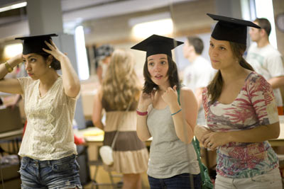 students pick up caps and gowns