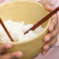 Child holding bowl of rice