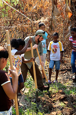 Bryan Sobel, MS candidate in the Graduate Field of Horticulture, demonstrates how to break ground for a garden bed. The students built two gardens outside the school in Barranco, a Garifuna Village in the Toledo District in southern Belize.