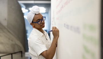 AAP student Milan Taylor works on her installation during the Cornell Council for the Arts Freedom of Expression Exhibition opening reception in Milstein Dome.