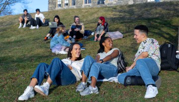 Students hang out on Libe Slope on a warm winter day.