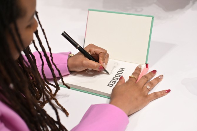 Malika Grayson, M.S. ’14, Ph.D. ’17, signing copies of her book after delivering a keynote speech at Towson University.