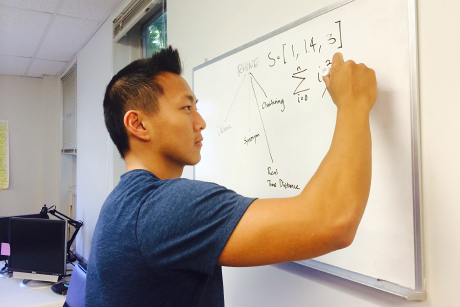 team member outlines an algorithm on white board