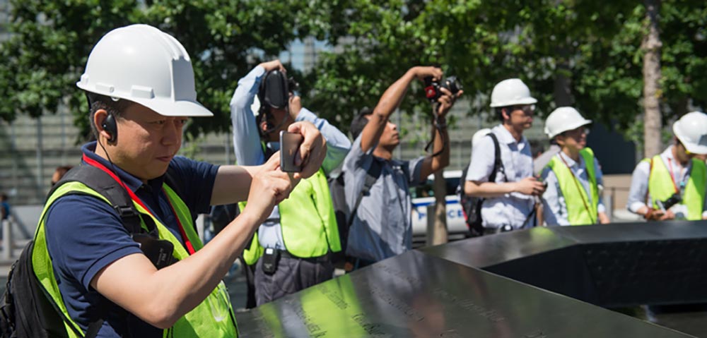 Man i hard hat taking photo of 9/11 museum