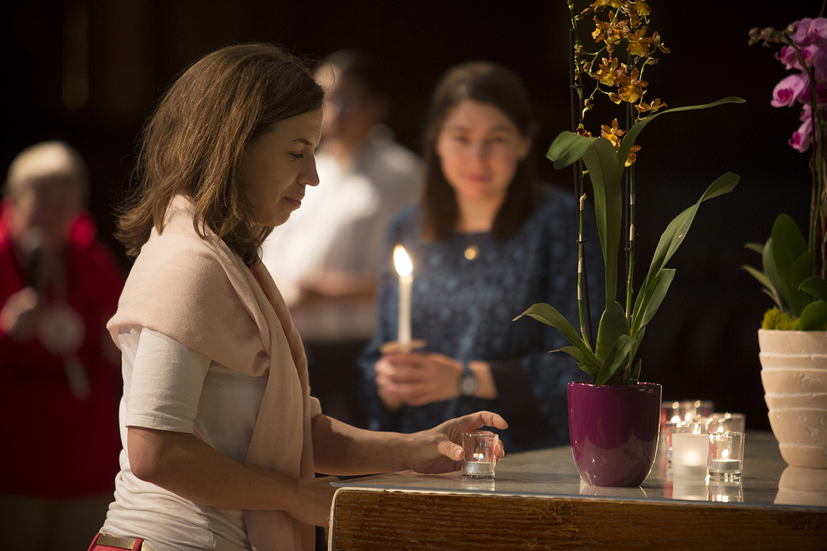 Woman lights votive candles
